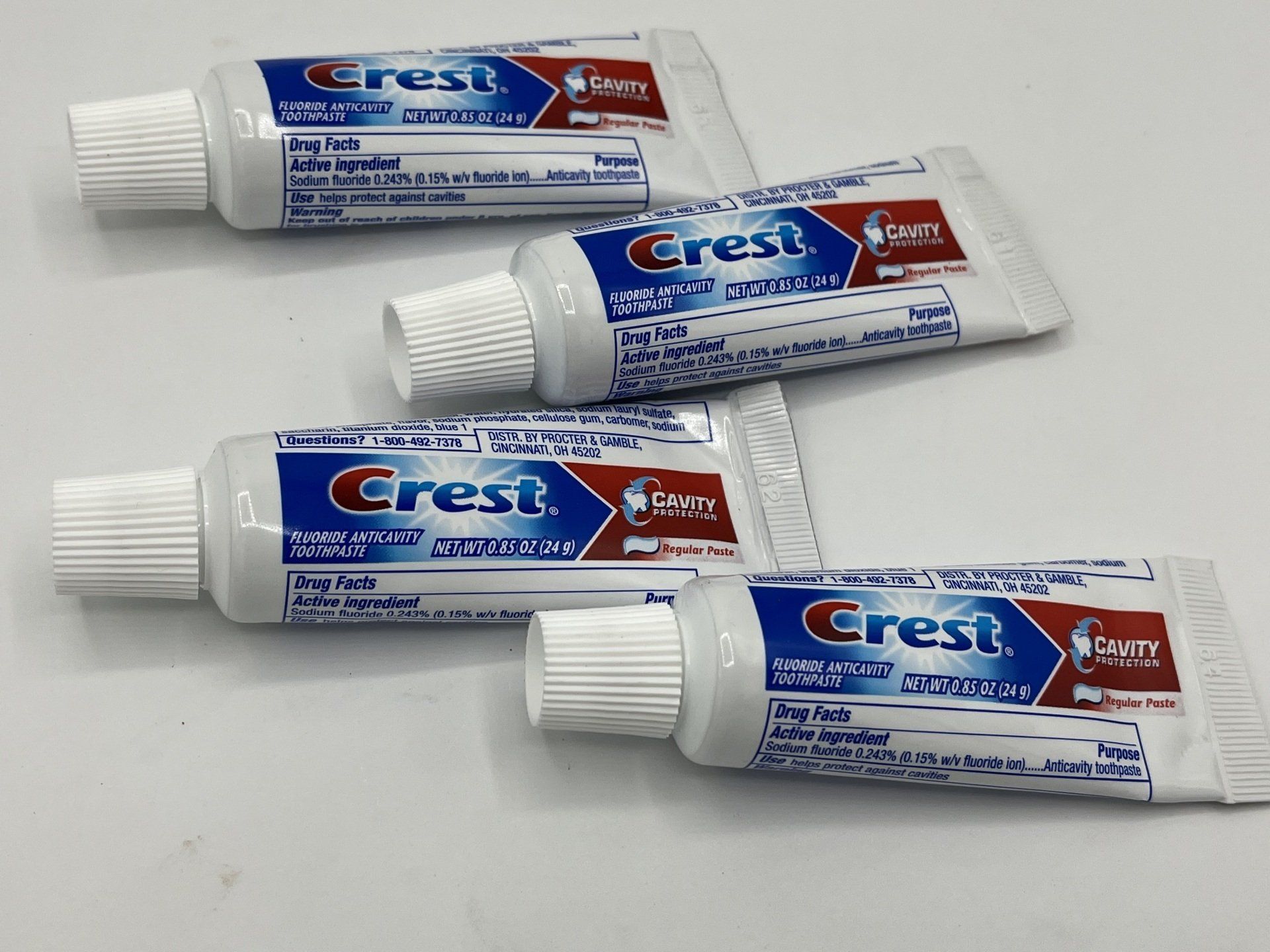 Four tubes of crest toothpaste are sitting on a table