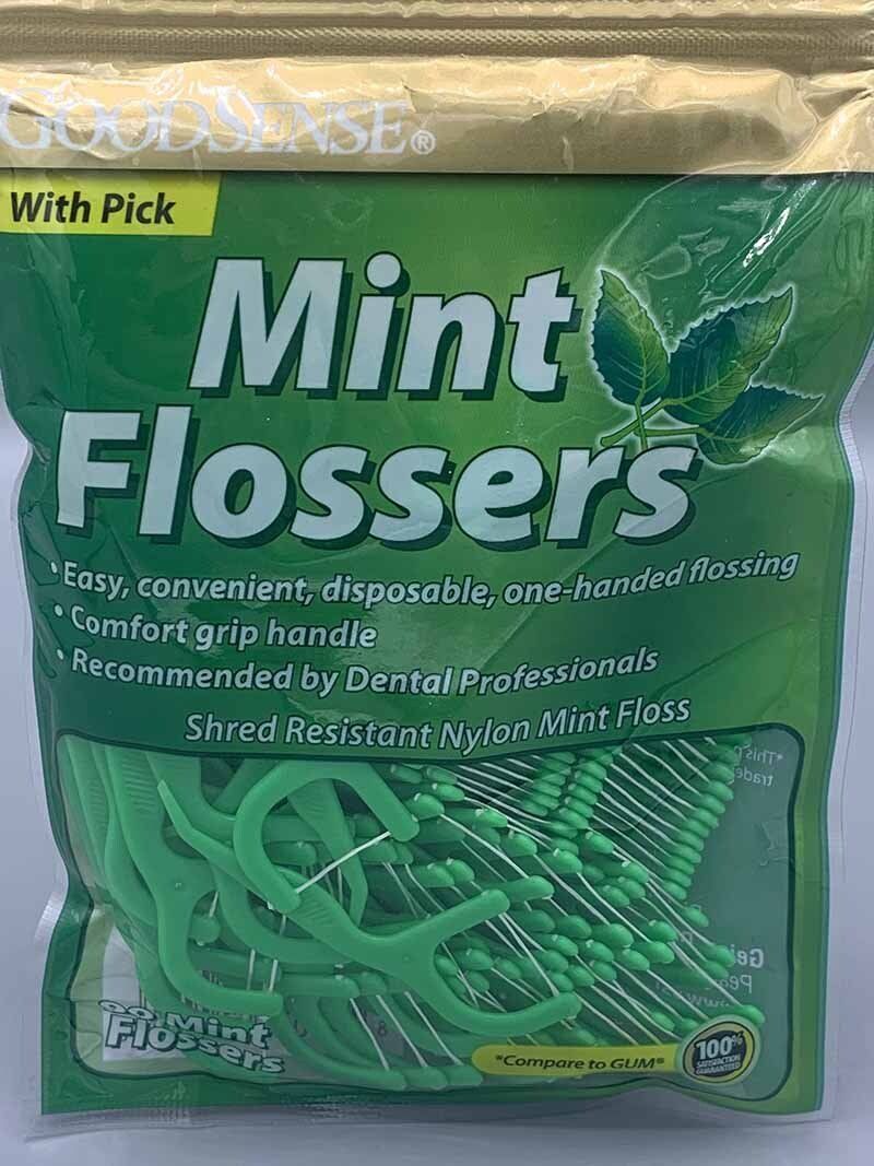 A bag of mint flossers with a pick on a white surface.