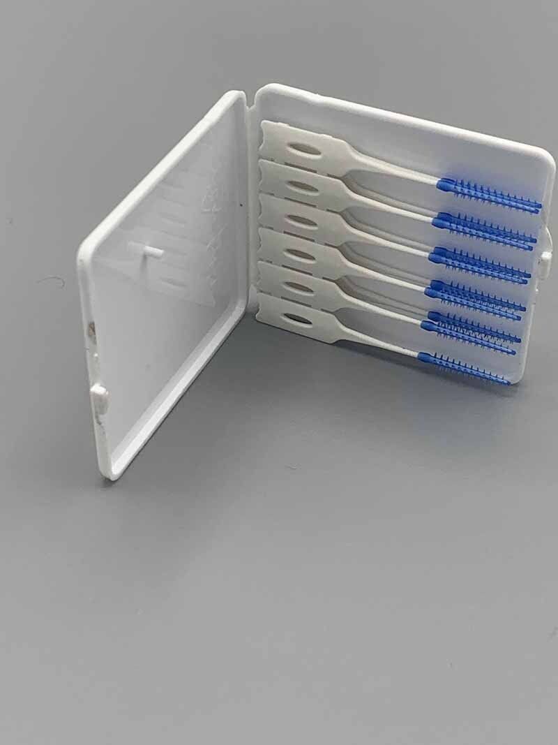 A white box filled with toothbrushes on a gray surface.