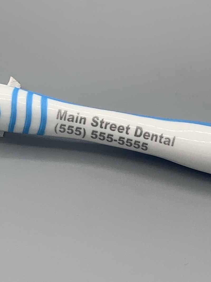 A pen with the name main street dental on it is sitting on a table.