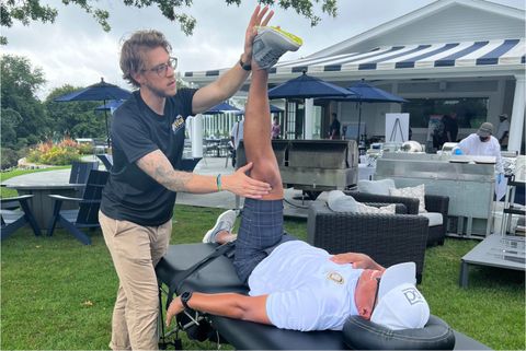 a man is stretching a woman 's leg on a table .