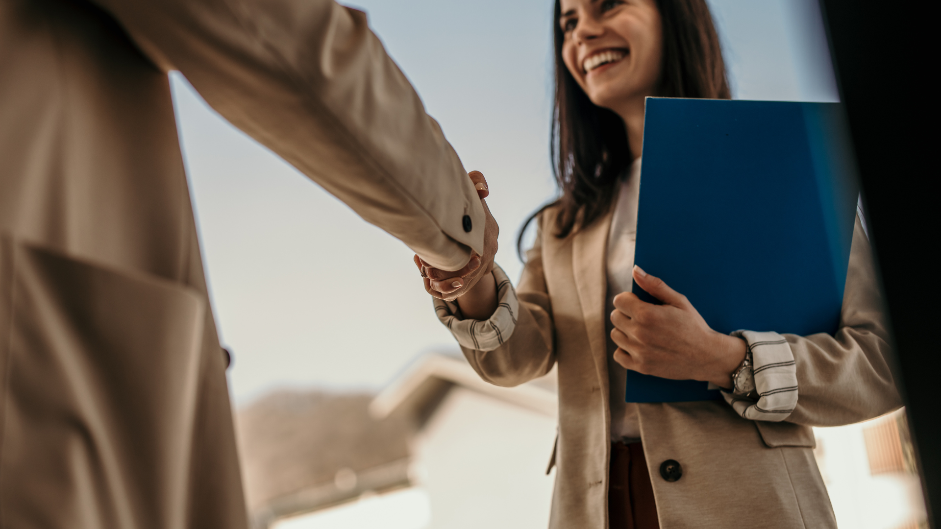 A female doctor is wearing a white coat and a stethoscope around her neck.