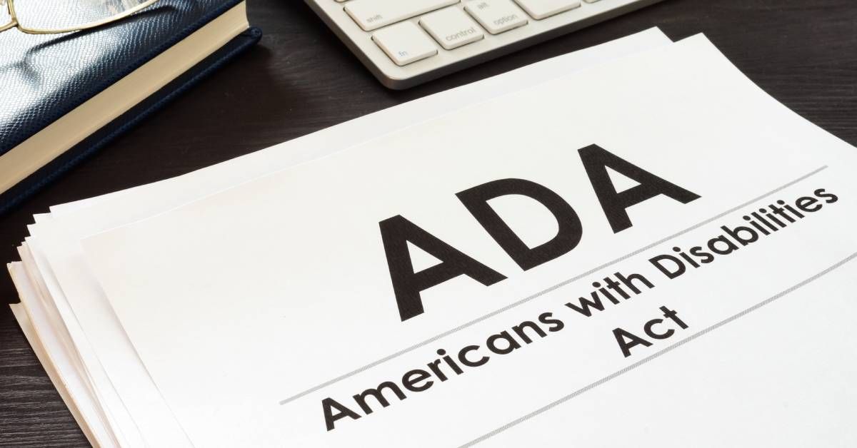 A document labeled ADA with eyeglasses placed on top, resting on a desk surface with printed text vi
