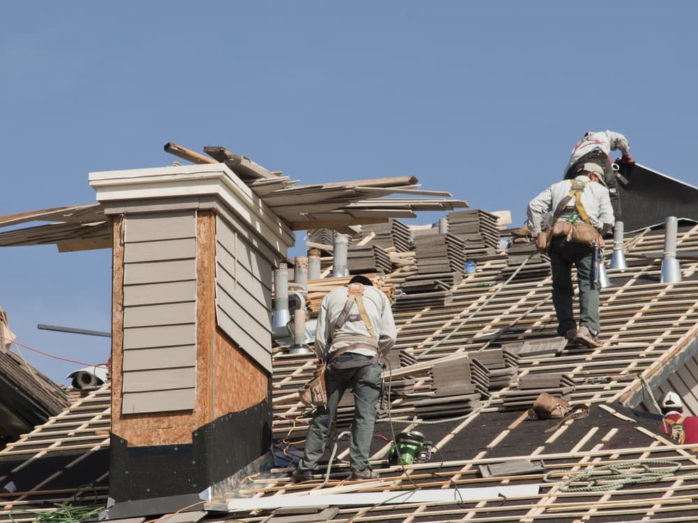 A Group of Men Are Working on The Roof of A House — Rooftop Northern Rivers In Ballina, NSW