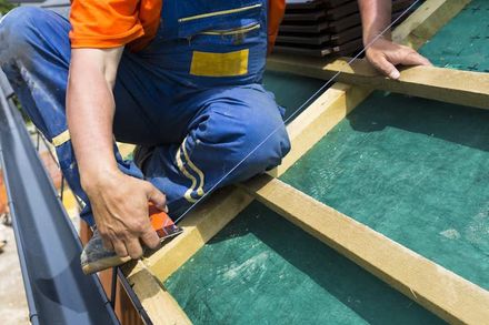 A Man Is Working on A Roof with A Hammer — Rooftop Northern Rivers In Ballina, NSW