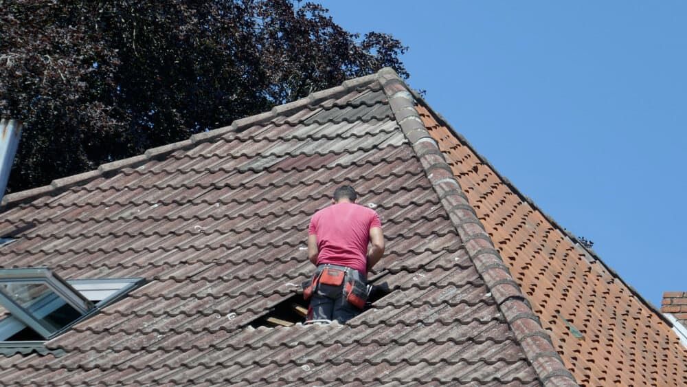 A Man Is Standing on The Roof of A Building — Rooftop Northern Rivers In Ballina, NSW