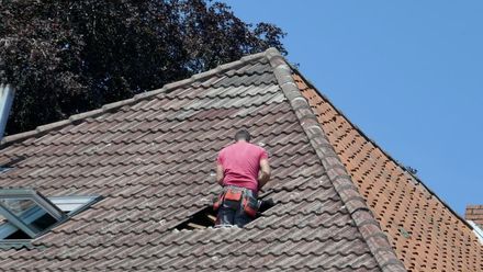 A Man Is Standing on The Roof of A Building — Rooftop Northern Rivers In Ballina, NSW