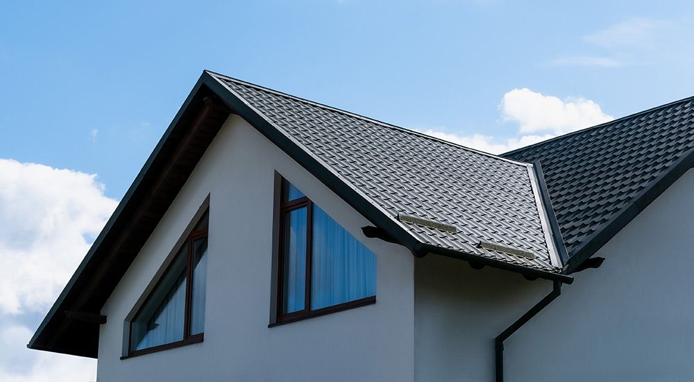 A White House With a Black Roof and a Blue Sky in the Background — Rooftop Northern Rivers In Yamba, NSW