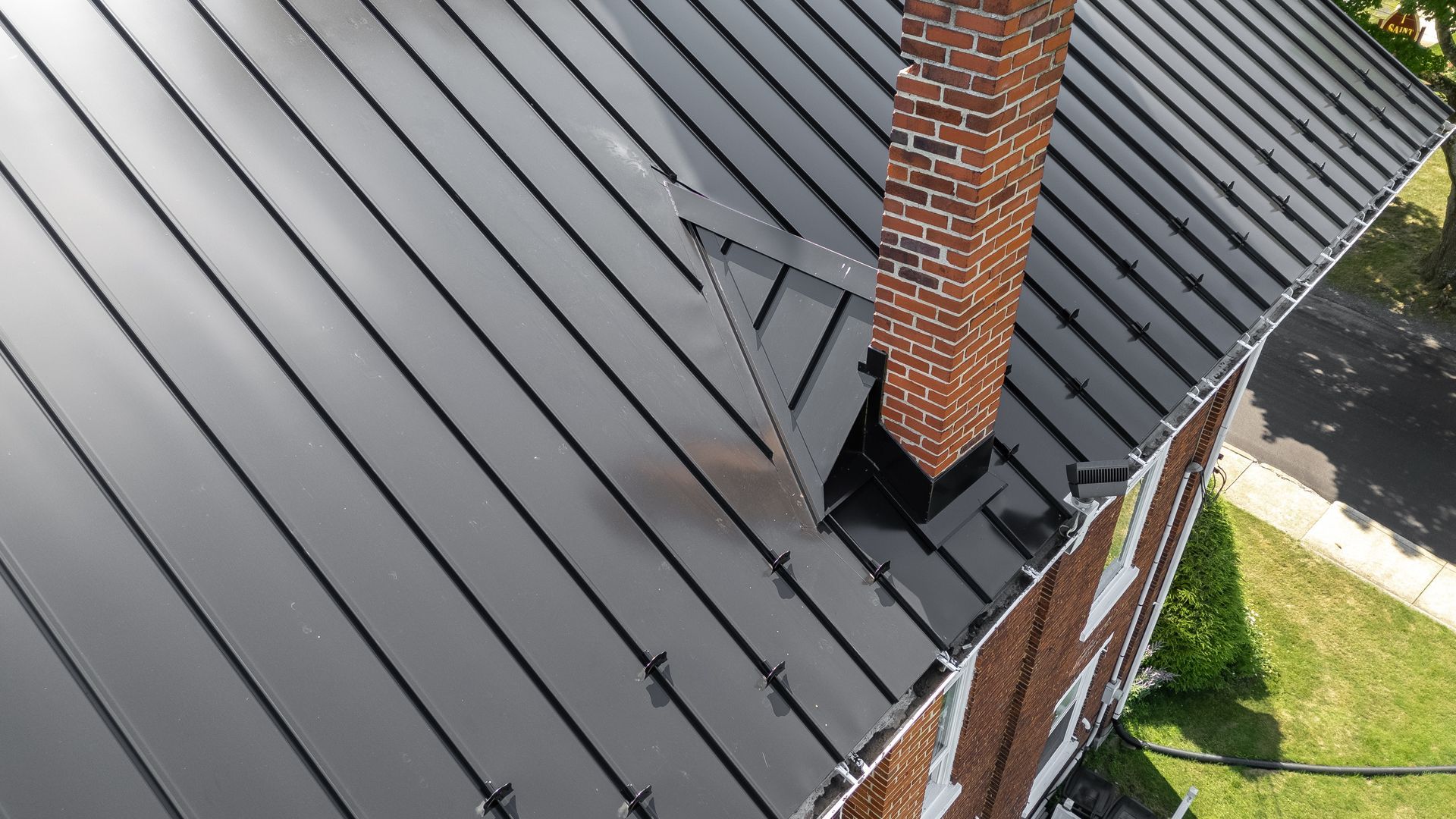 Black metal roof with brick chimney.