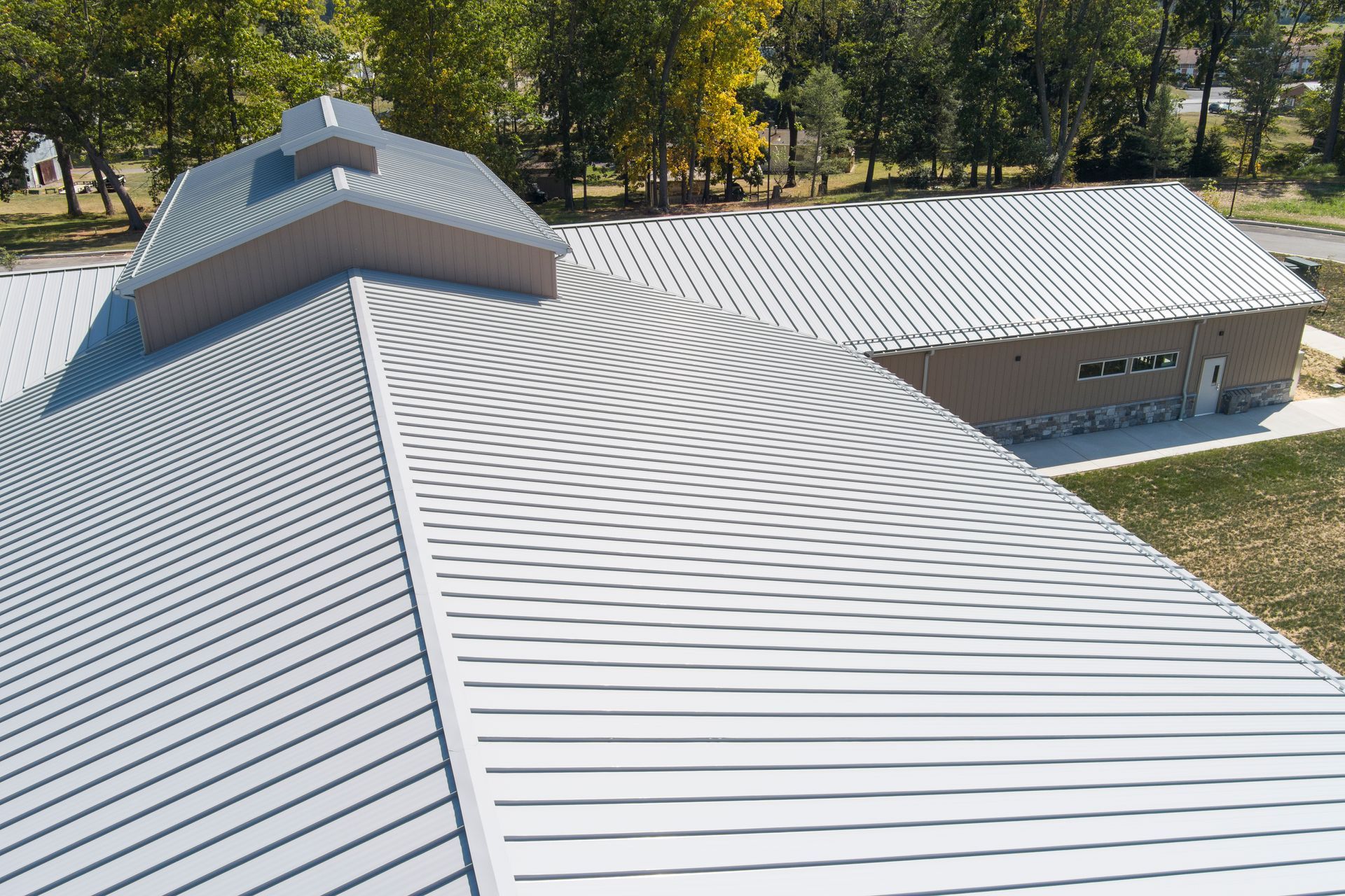 High-angle view of a metal roof showing a moiré pattern effect across the overlapping panels and ridges.