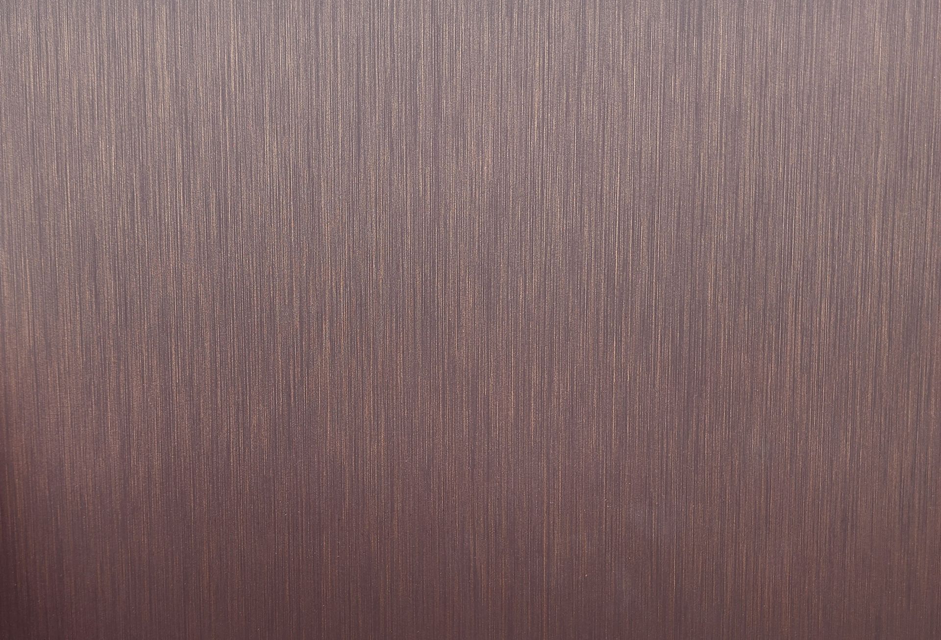 Brushed metal surface, vertical grain, with a pinkish-brown hue.