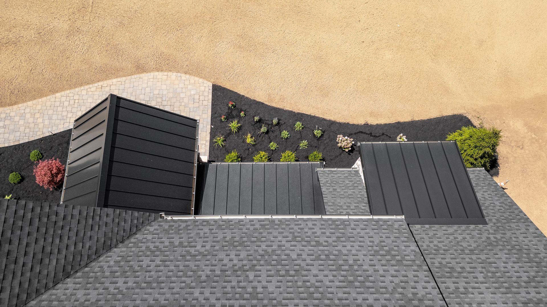 Overhead view of a modern house roof and garden with black and gray accents.