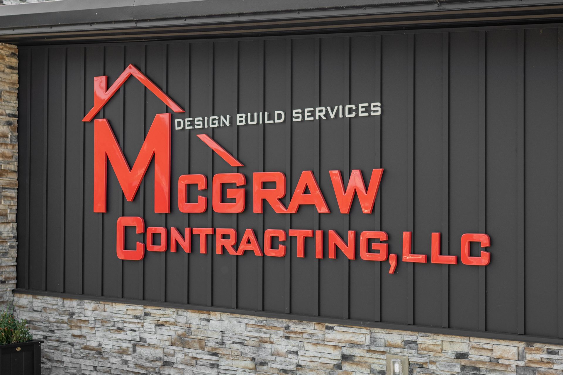 McGraw Contracting, LLC sign in red on a dark gray building, with a house outline above the name.