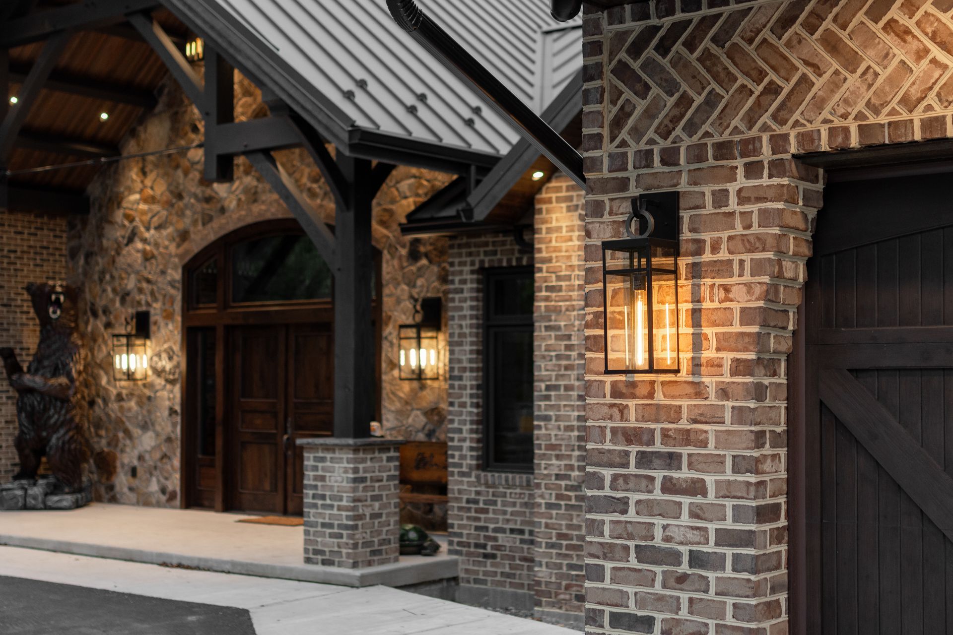 Exterior of a rustic building with stone and brick, lit by warm lights.