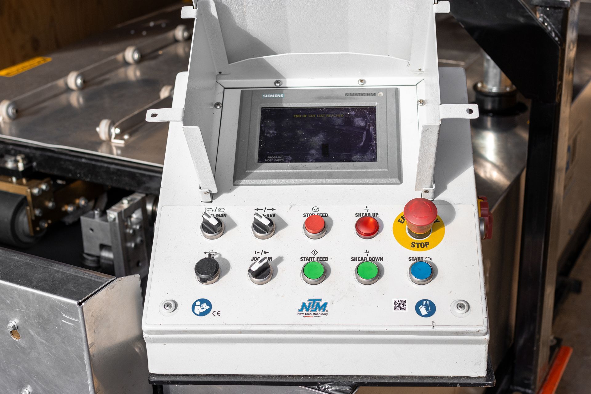 Control panel with buttons, touchscreen, and emergency stop.