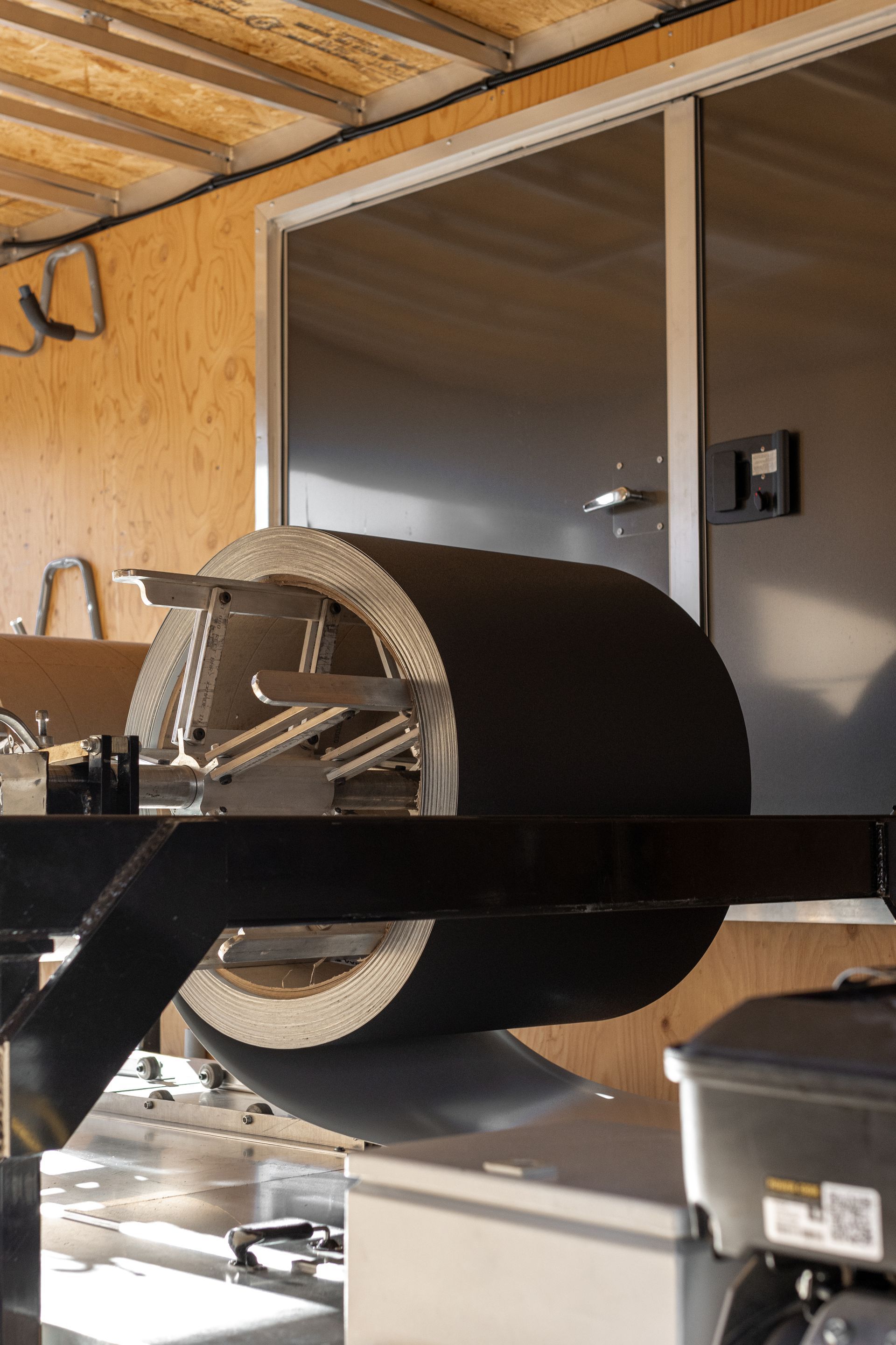 A large, cylindrical object with metal supports spins in a trailer.