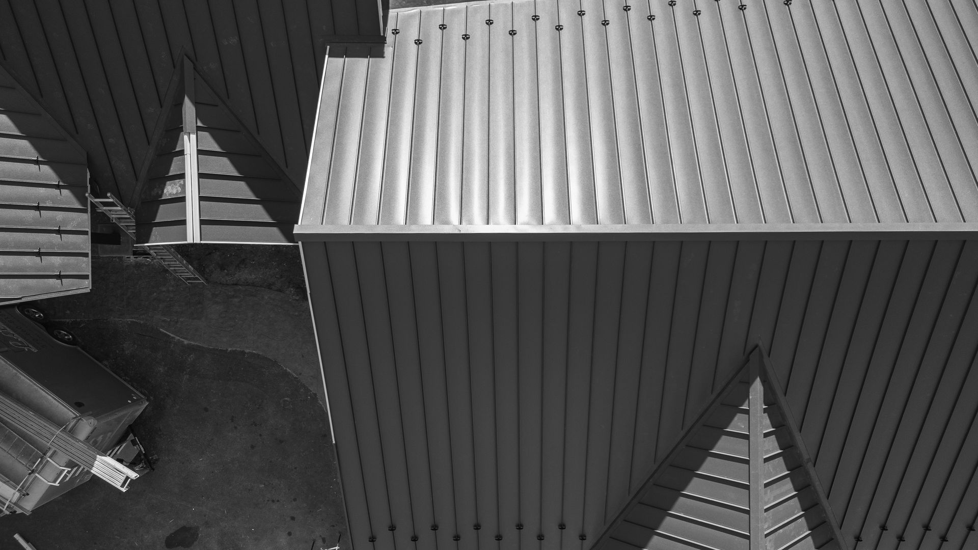Overhead view of corrugated metal roofs, creating interesting shadows and angles.
