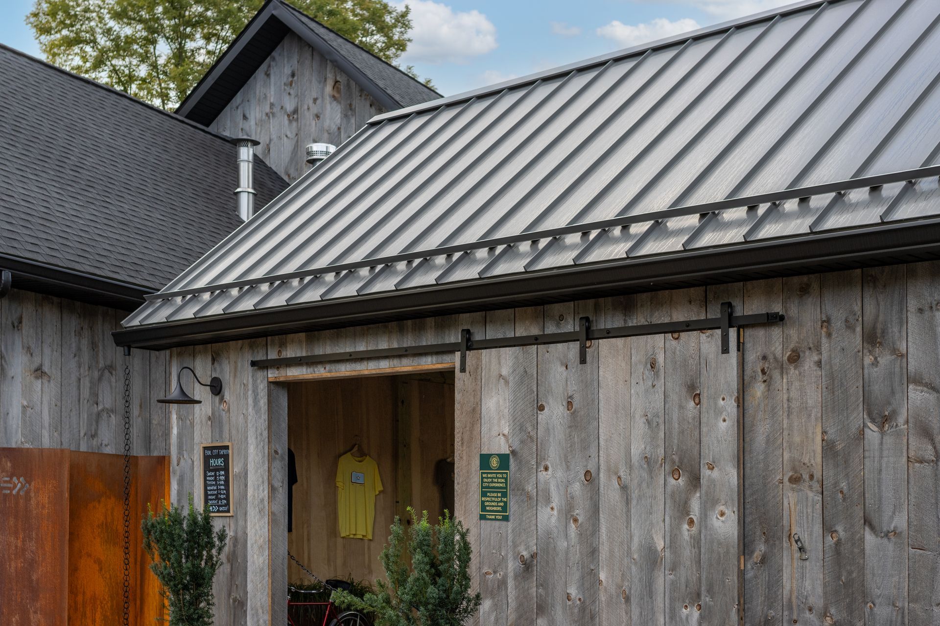 Weathered barn with a metal roof and sliding barn door.