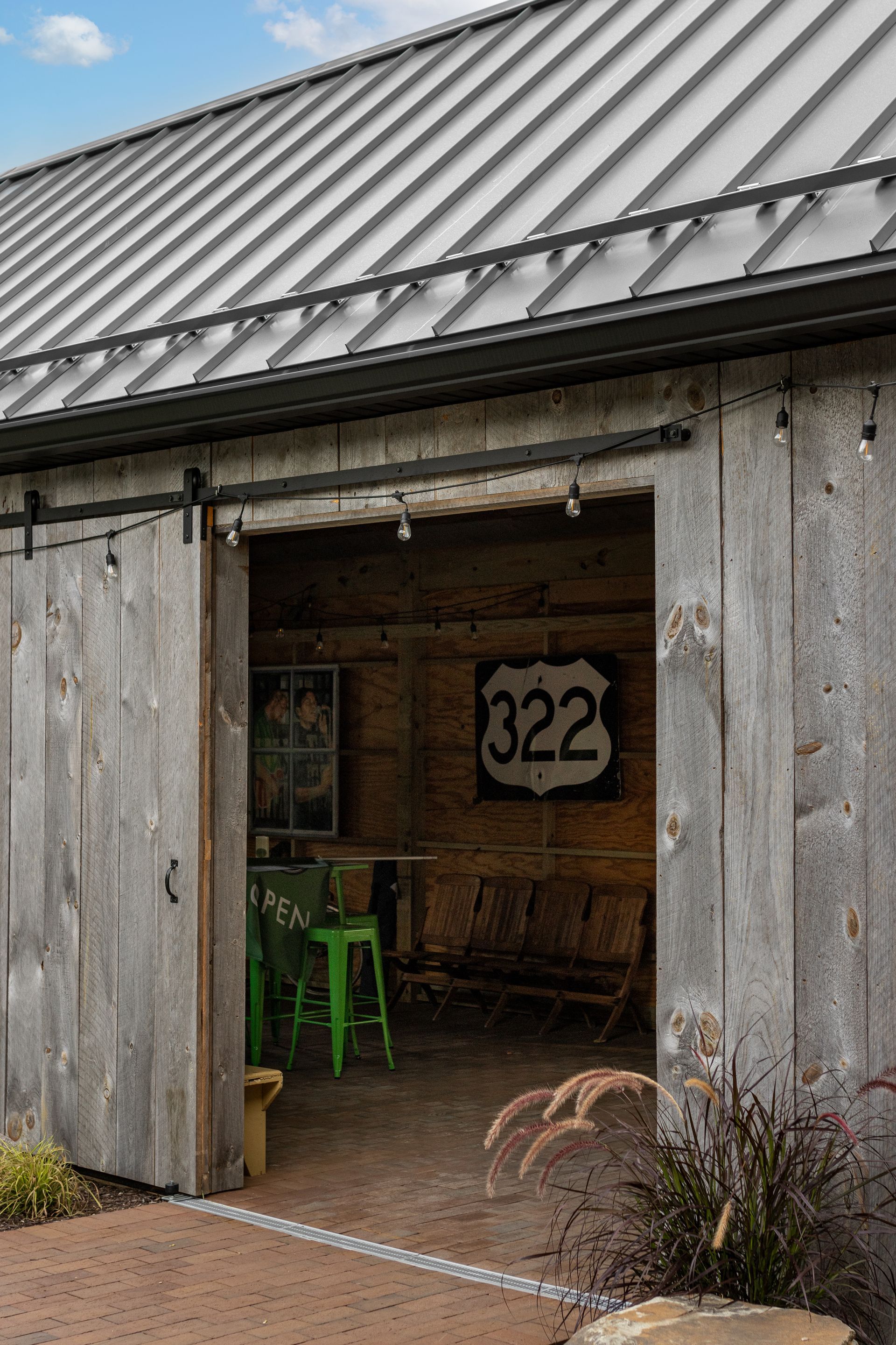 Wooden barn with sliding door, showing interior with seating and a 