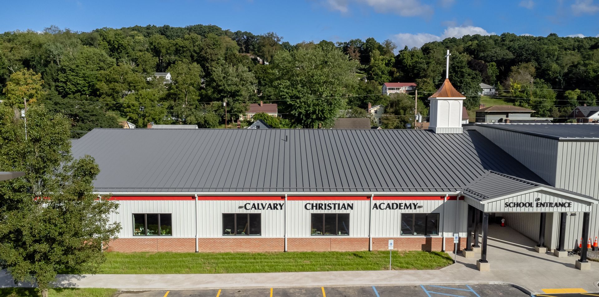Exterior view of Calvary Christian Academy with a grey roof and red trim.