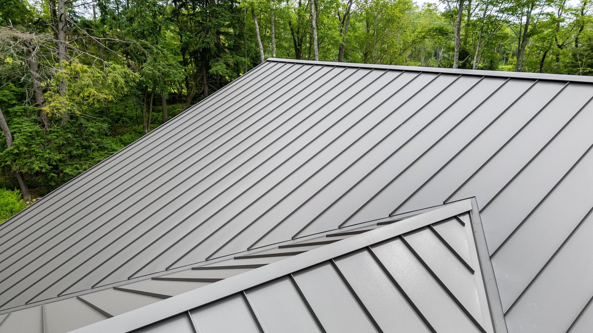 Side angle showing sleek metal roof and stone base of Dellulo Garage, State College.
