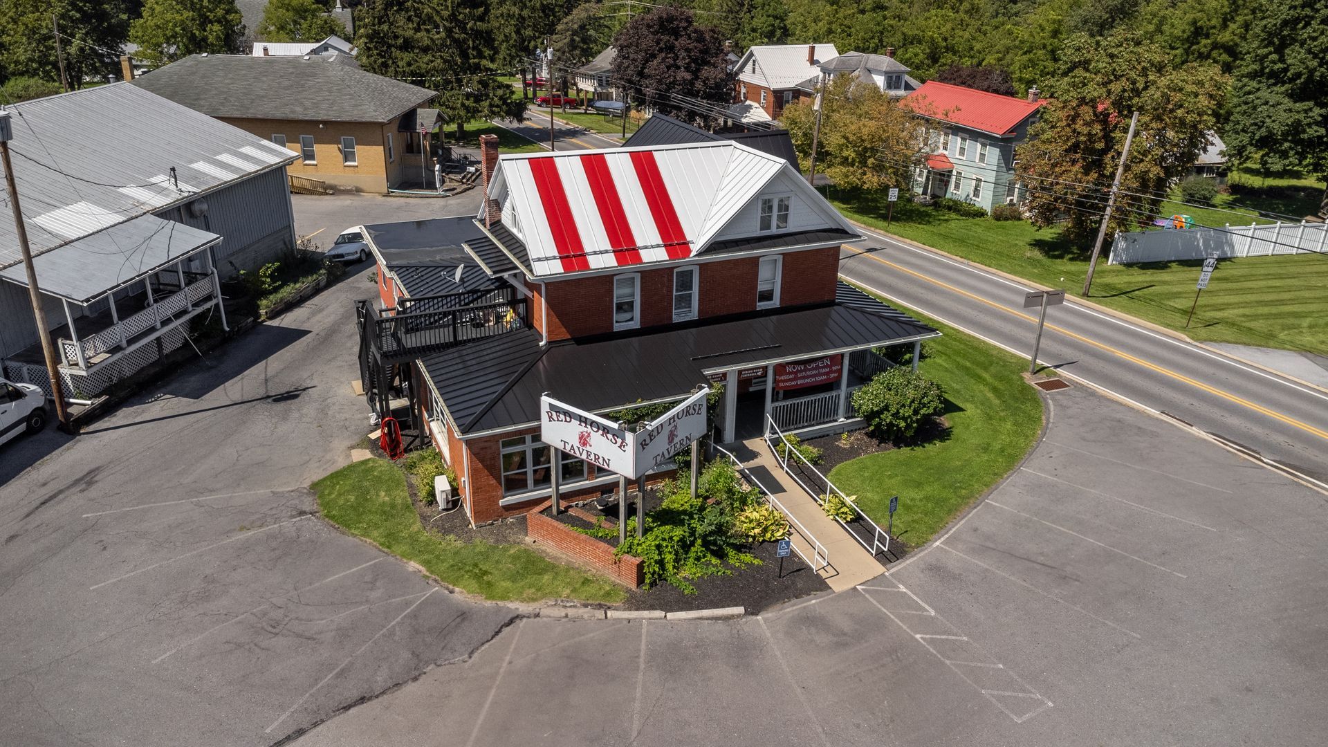 Restaurant with a red and white striped roof, brick exterior, and a ramp for accessibility.