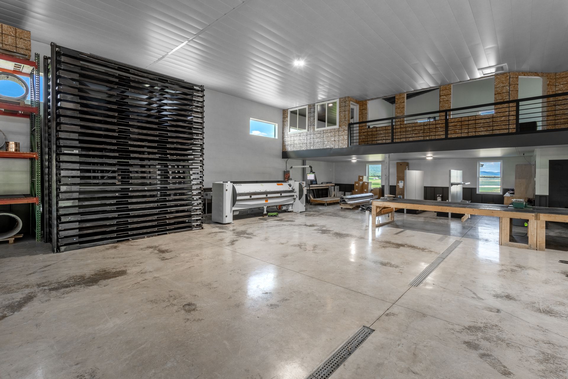 Large workshop with open floor, equipment, and a raised mezzanine area.