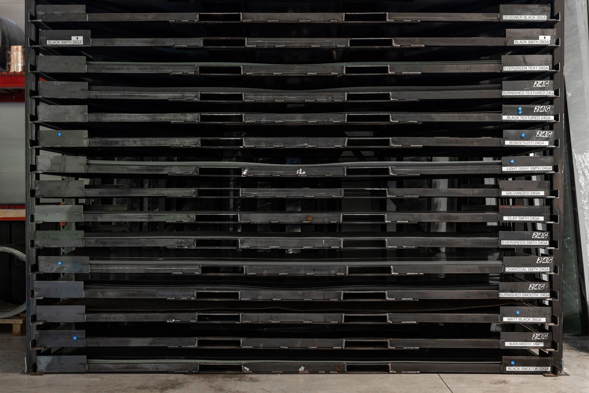 Stack of black industrial pallets in a warehouse setting.