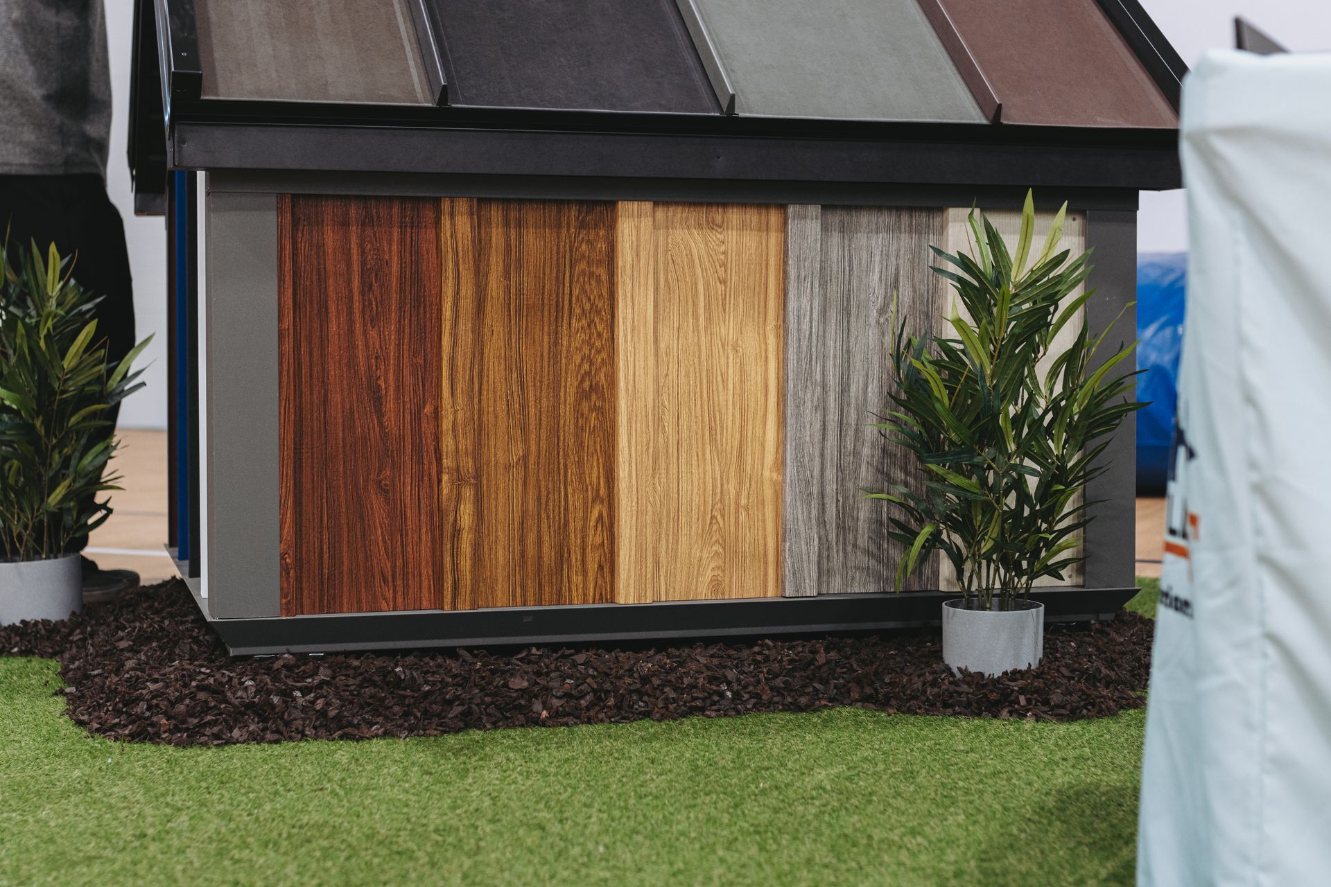 Display of wood panels in various colors for siding, showcasing roofing samples.