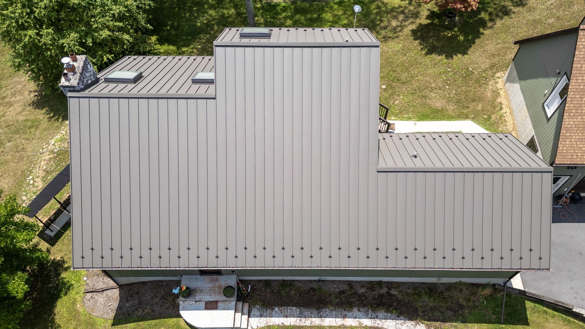 Overhead view of a house with a gray metal roof and a small porch.