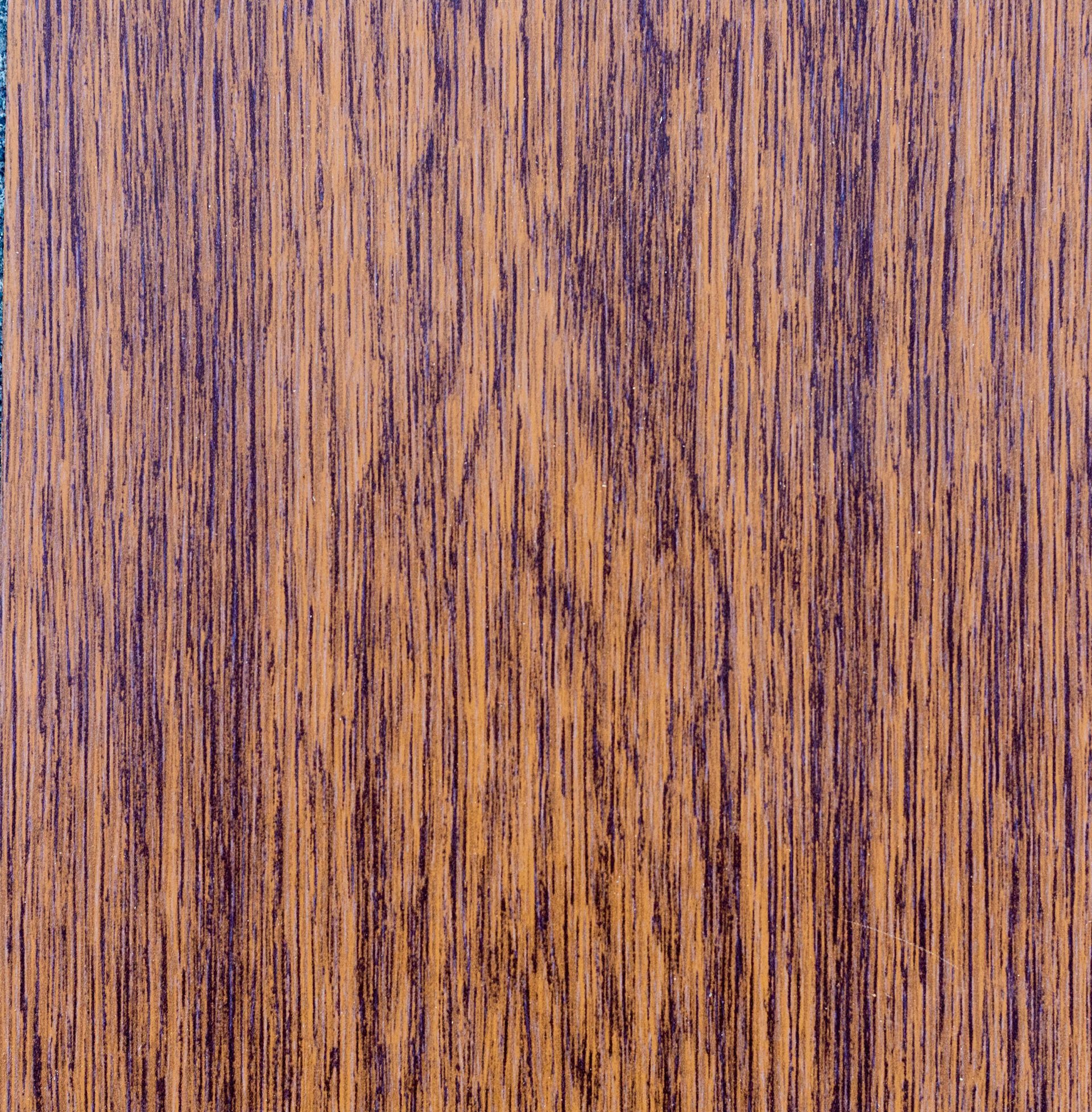 Close-up of woodgrain with dark brown and golden-brown vertical streaks.