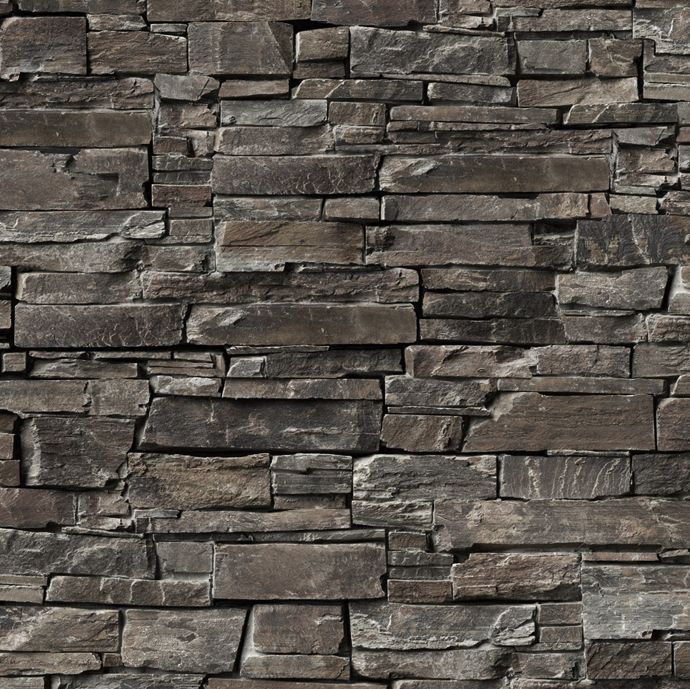 Stone wall with layered, irregularly shaped dark gray and brown stones.