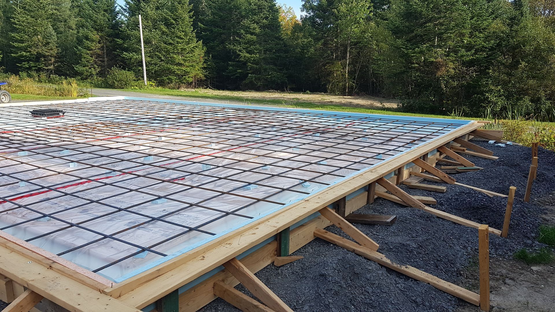 Coffrage en bois pour béton avec armature et isolation, prêt à recevoir le béton.