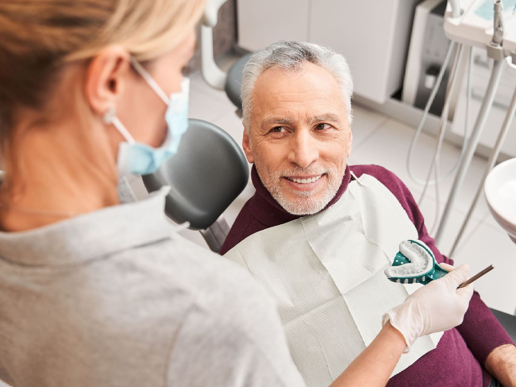 A woman is getting her teeth checked by a dentist