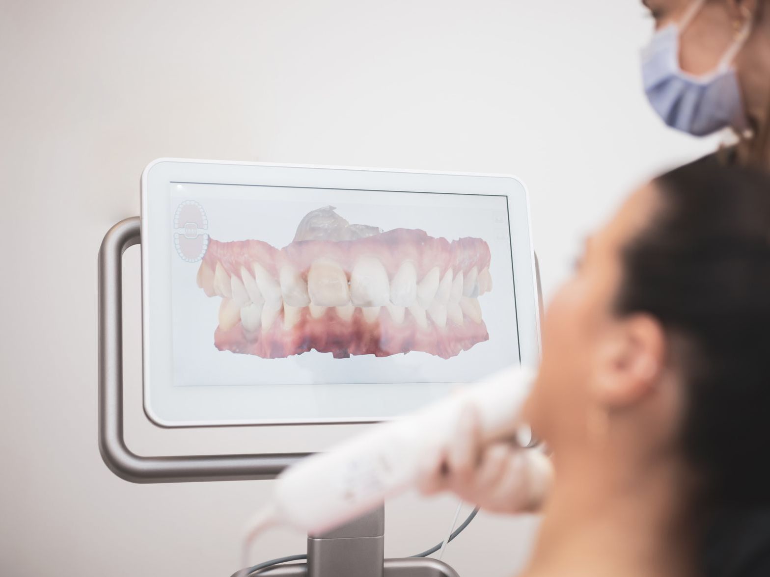 A woman is getting her teeth checked by a dentist