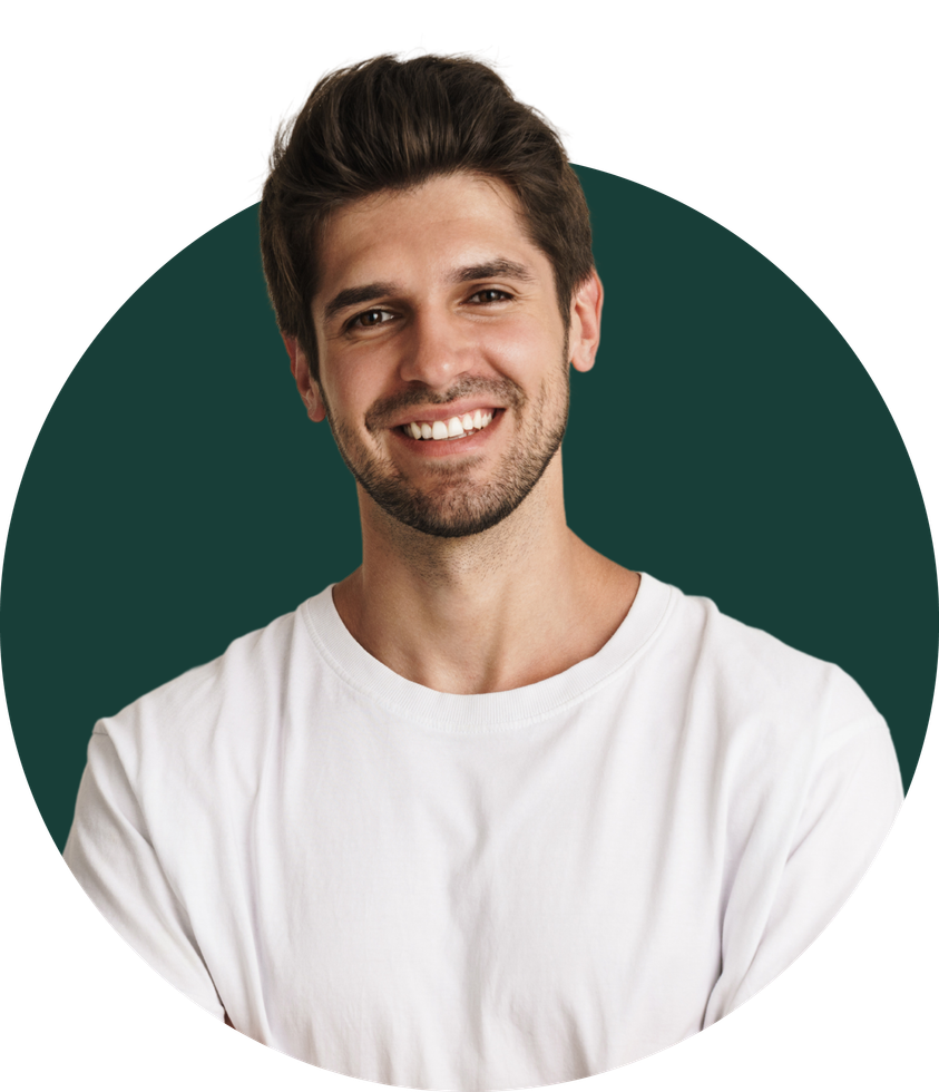A man with a beard wearing a white shirt is smiling with his arms crossed.