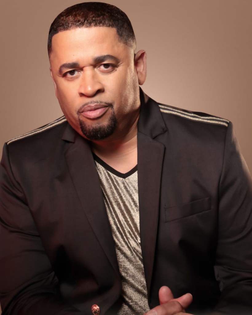 A man with a beard is wearing a black jacket.