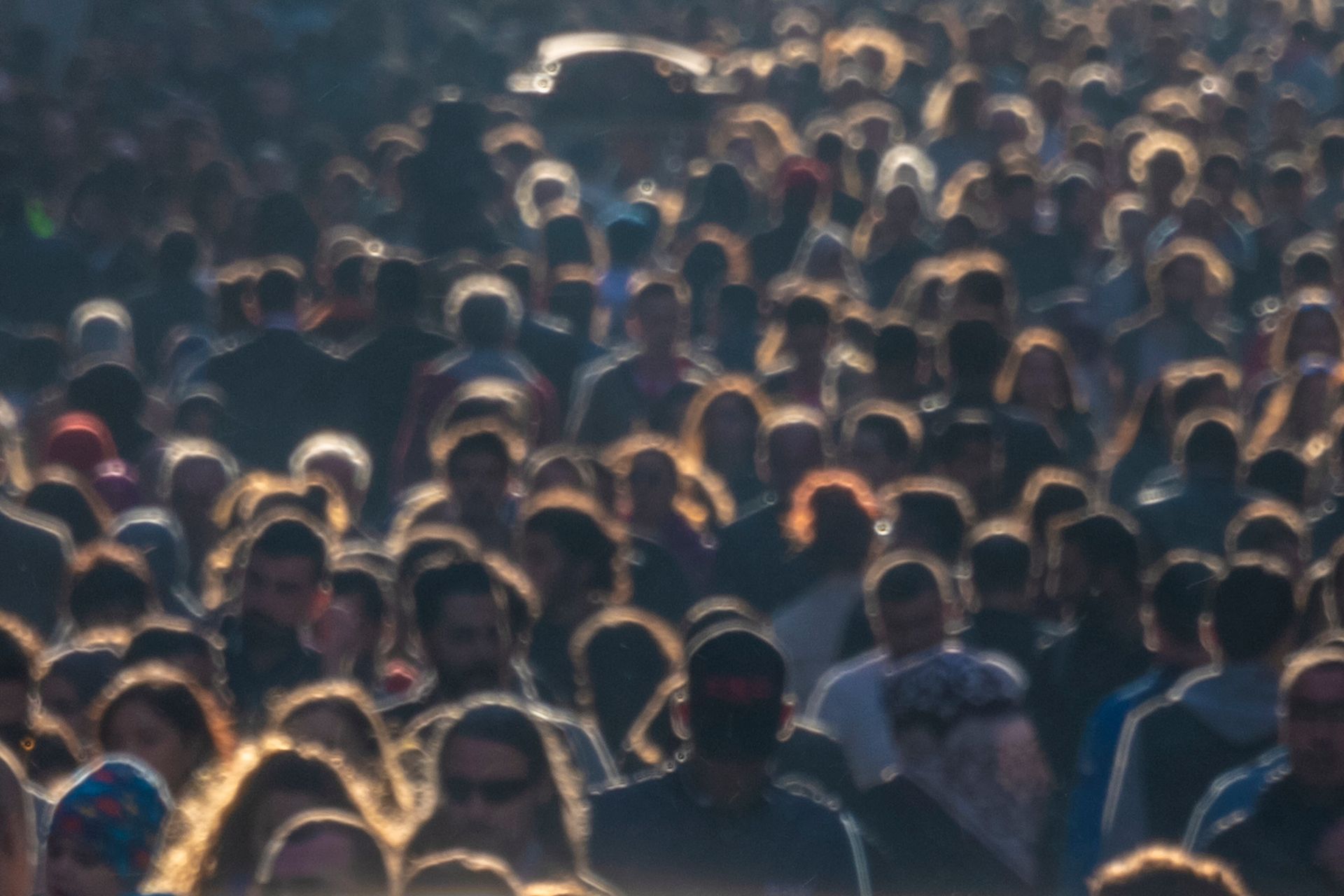 A large crowd of people are gathered in a dark room.
