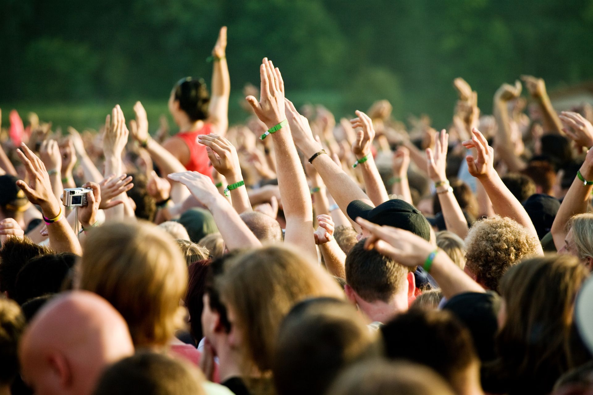 A crowd of people with their hands in the air at a concert