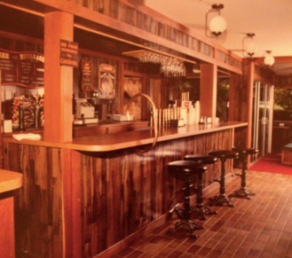 A restaurant with a wooden bar and stools