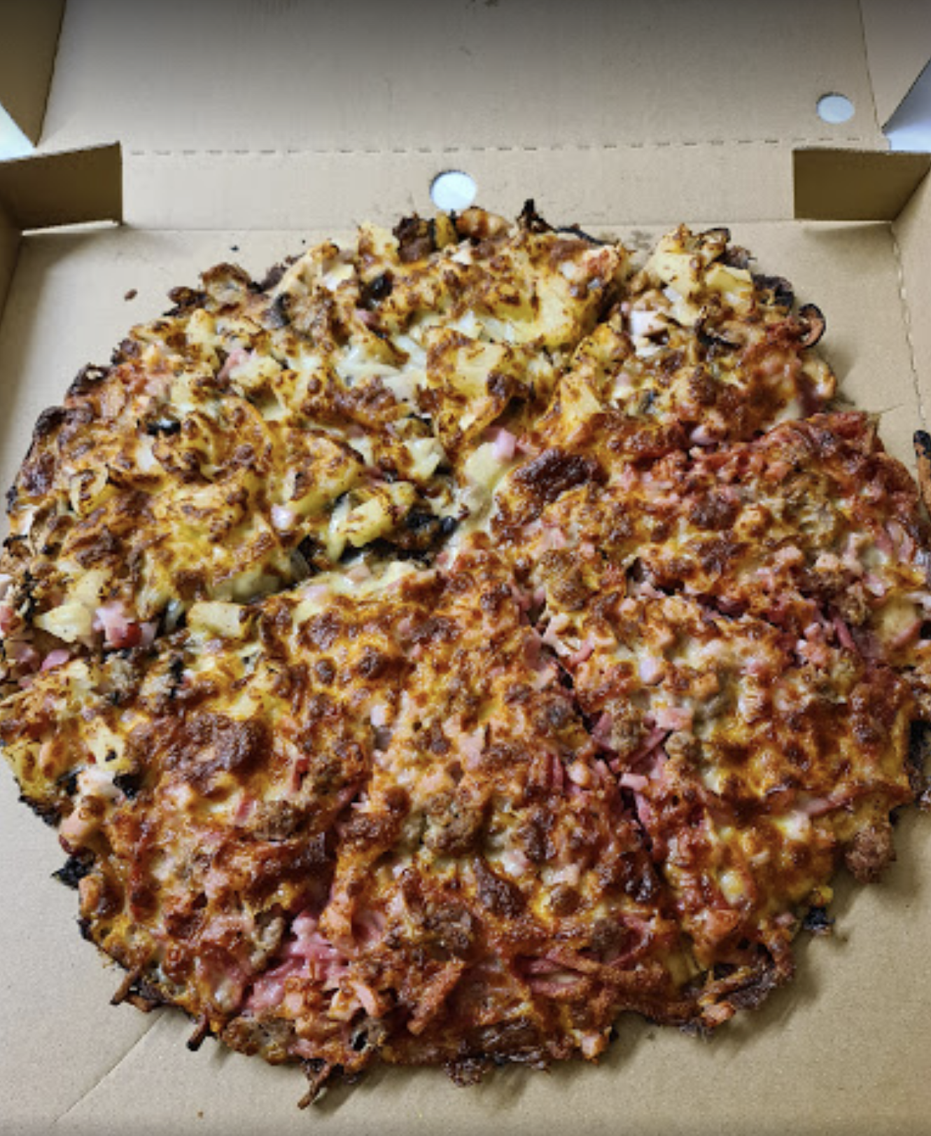 A pizza in a cardboard box with a slice missing — Bella M Pizzas in Bundaberg North, QLD