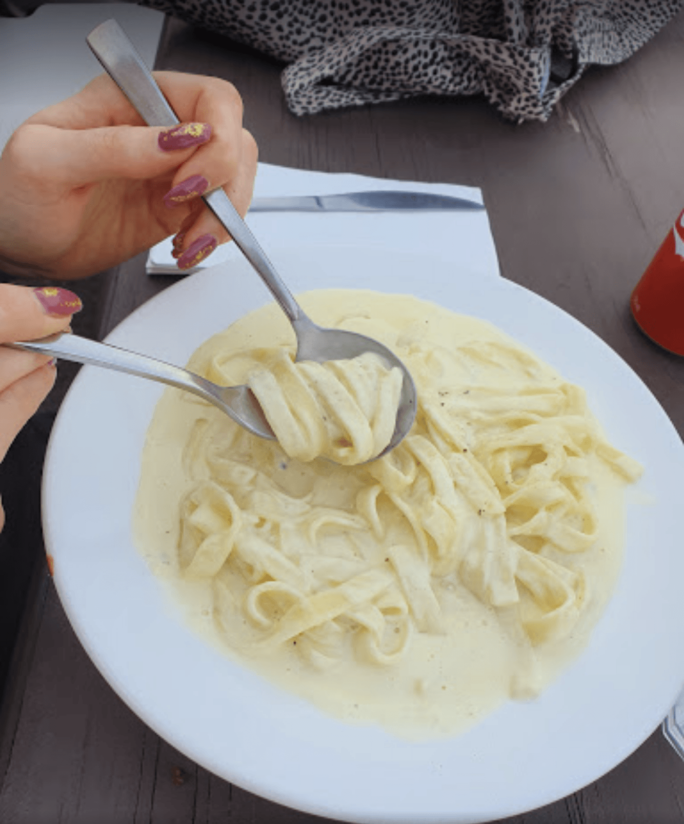 A person is eating pasta with a spoon and fork — Bella M Pizzas in Bundaberg North, QLD