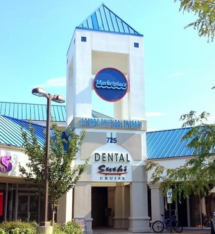 A white clock tower building with a blue roof, marked 