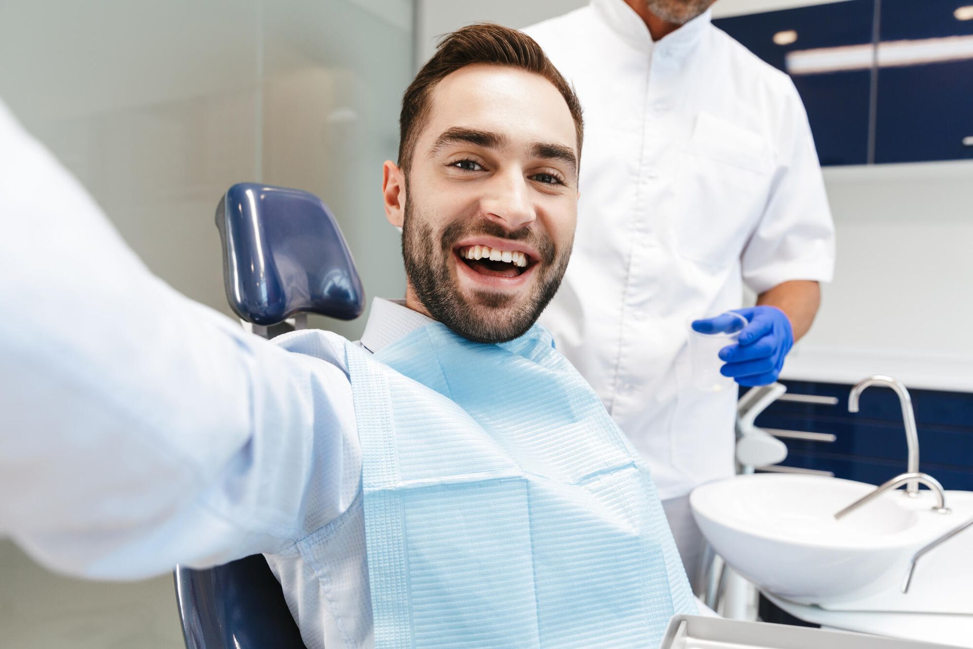 A man is taking a selfie in a dental chair.