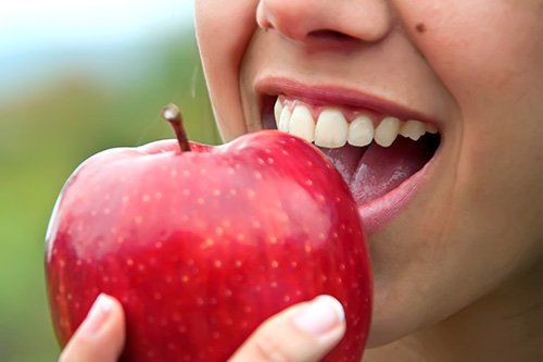 young person about to bite an apple