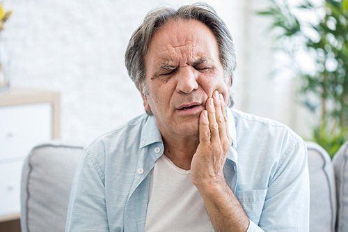 middle-aged male holding jaw with look of pain