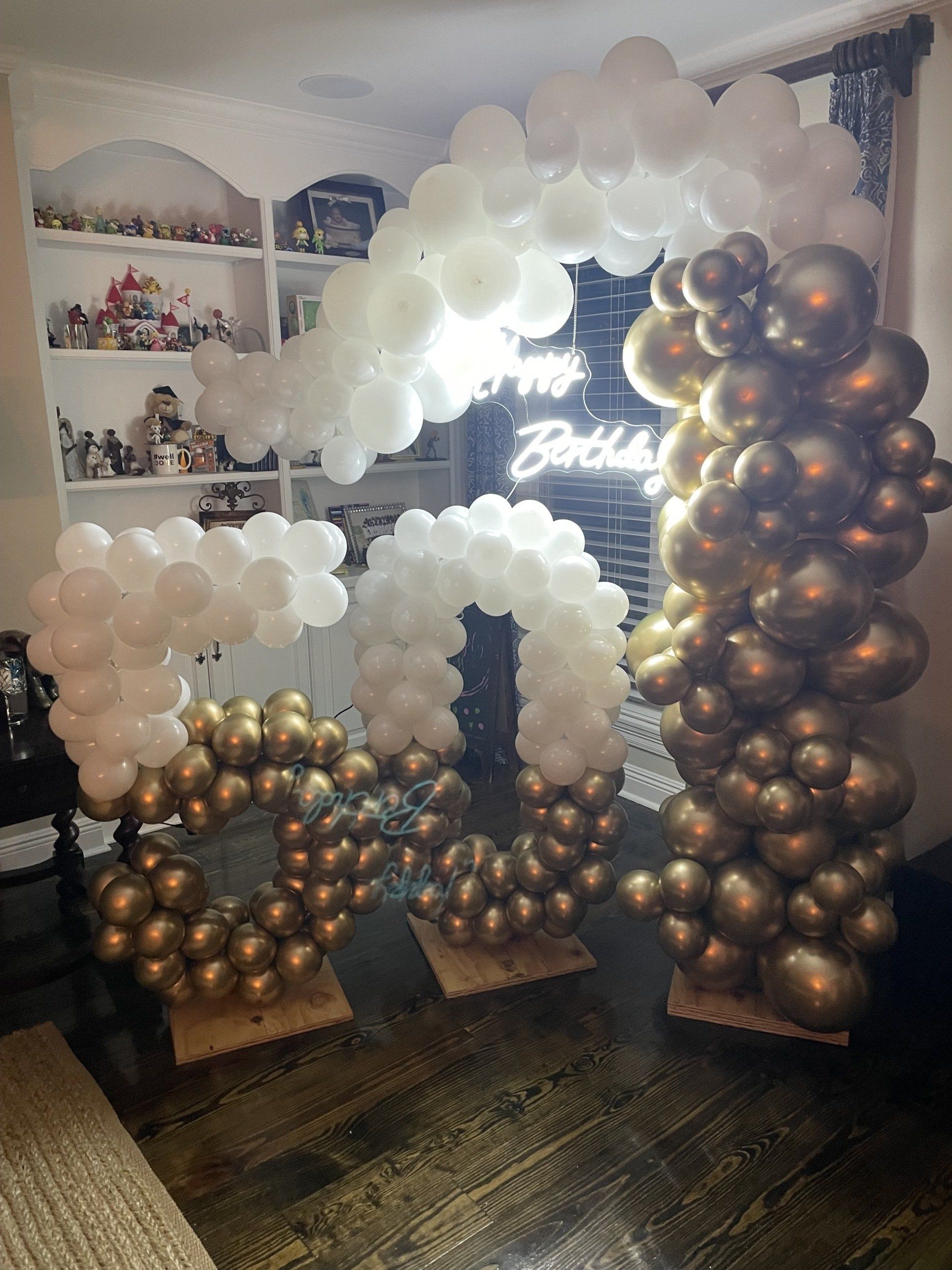 A room filled with balloons and a sign that says happy birthday.