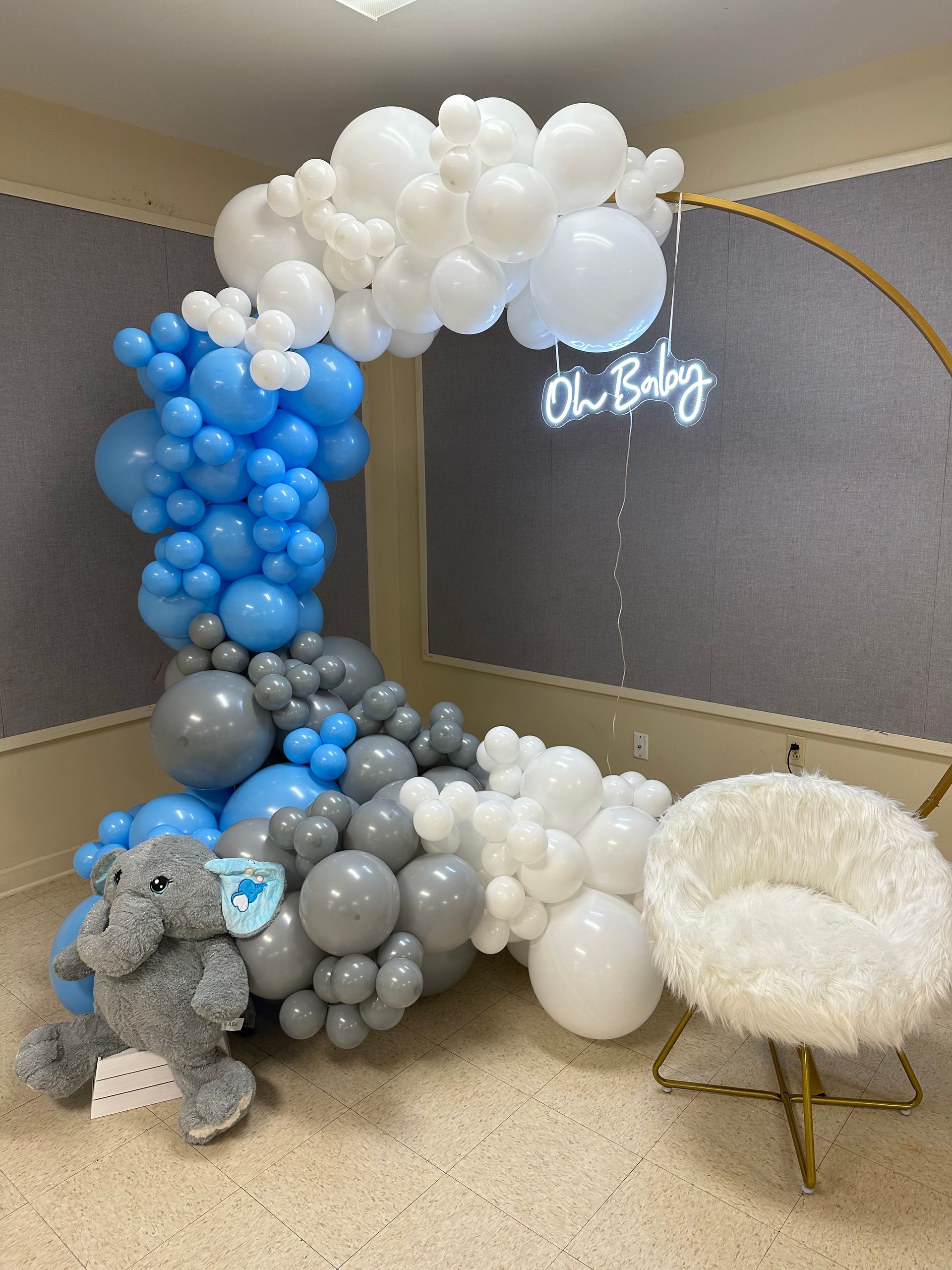 A room filled with balloons and a teddy bear.
