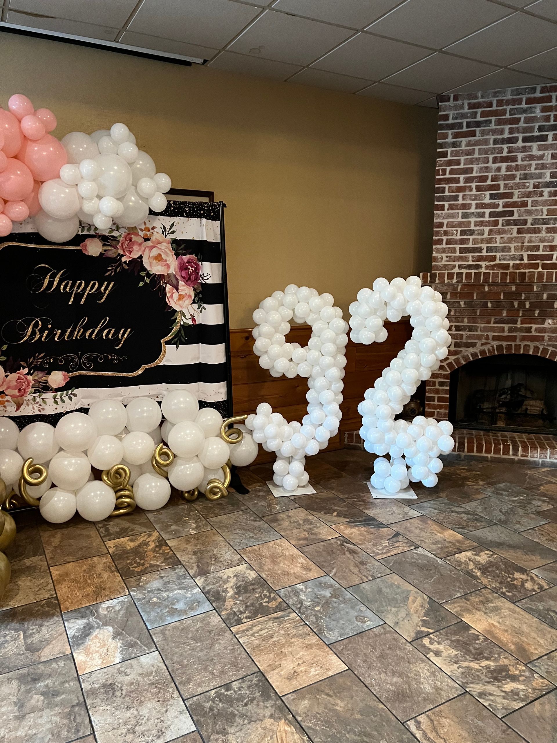 A room with balloons in the shape of the number 92.