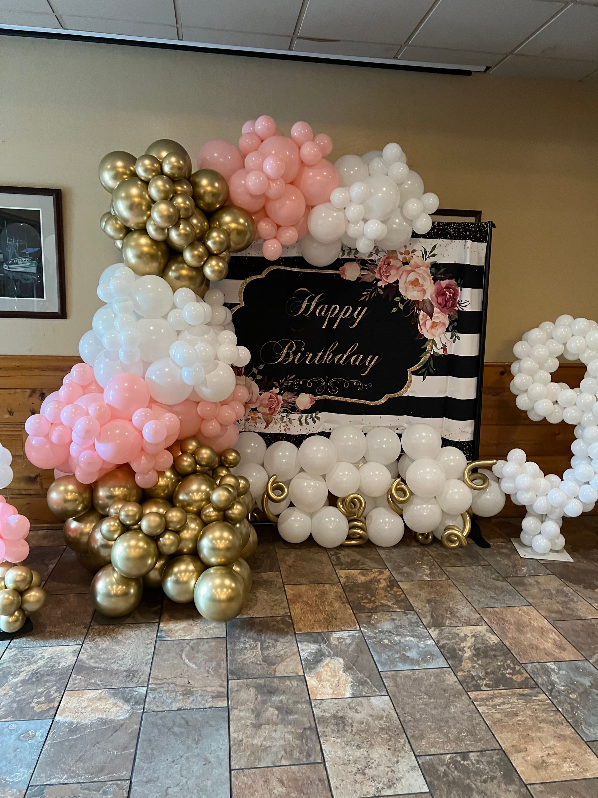 A room filled with balloons and a sign that says happy birthday